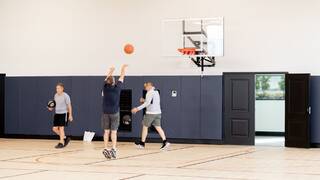 A group of active adults playing a game of basketball.